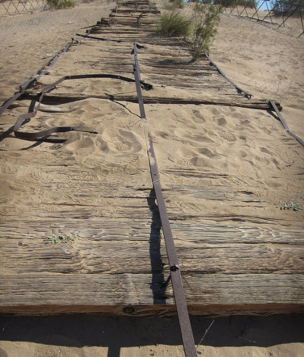 Close-up of wooden planks from the historic Plank Road with the wheel of a restored early automobile.