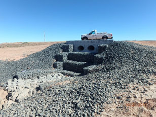 Large rocks surround drainage pipe Double drainage pipes flow onto steps